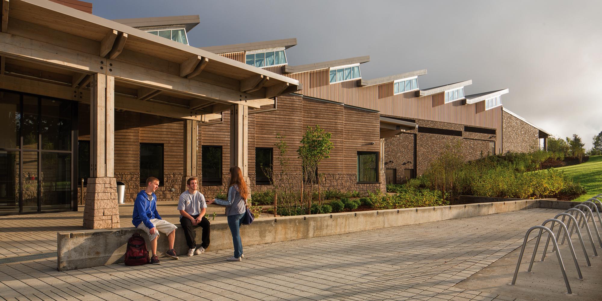 Students talking outside front entrance of Sandy High School